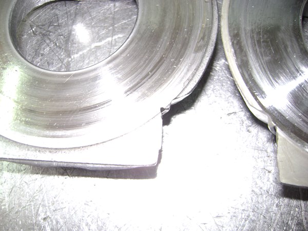 Porous casting and small machining imperfertions, like the over-cuts, reveal the aftermarket swashpalte
