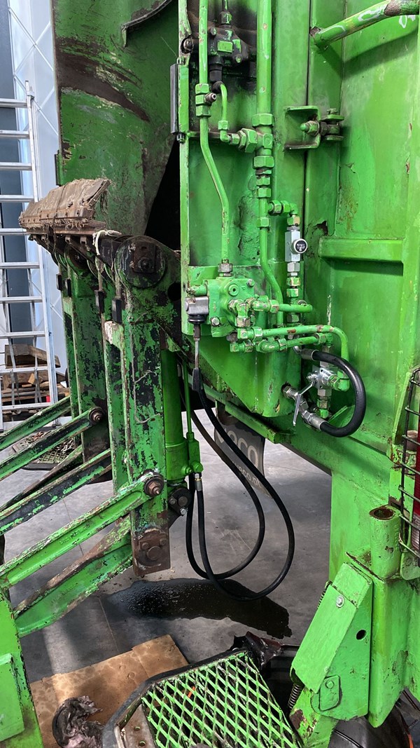 Two double-acting cylinders connected in parallel, moving the arms of a rear loader of a garbage truck