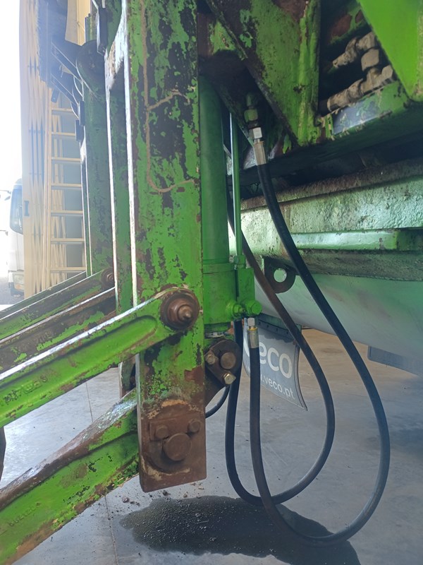 Two double-acting cylinders connected in parallel, moving the arms of a rear loader of a garbage truck